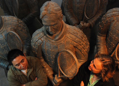 Sculptors Shen Xiaonan and Laury Dizengremel with Roger Federer sculpture and other tennis warrior statues